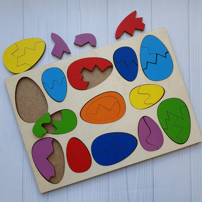 Wooden eggs taken apart into two and three pieces beside the tray, showing how each egg splits